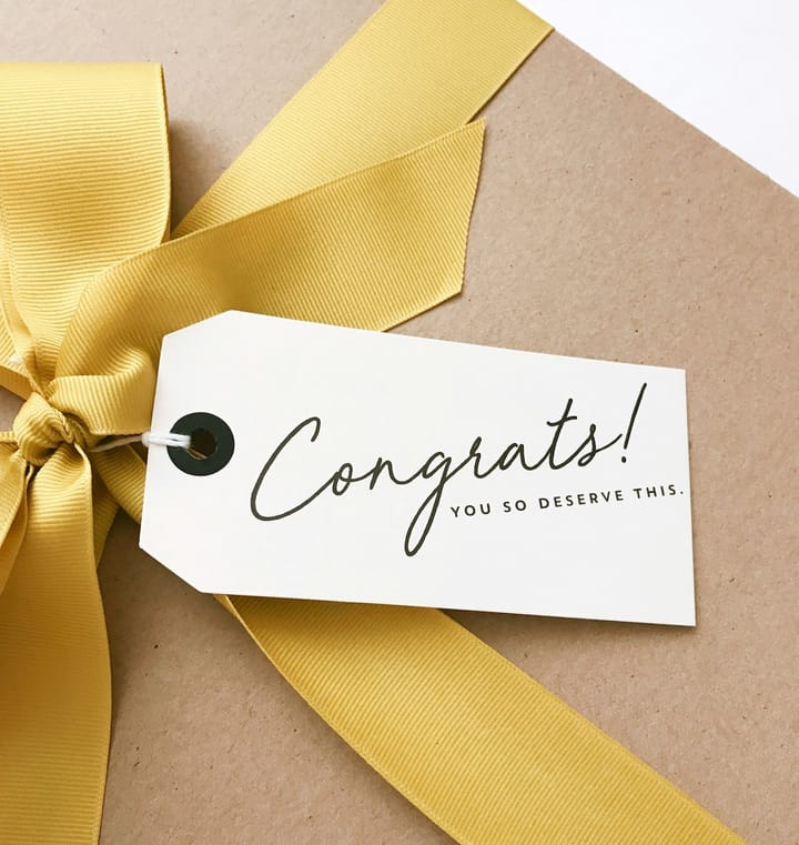 Gift with yellow ribbon and a gift tag saying "Congrats! You deserve this."